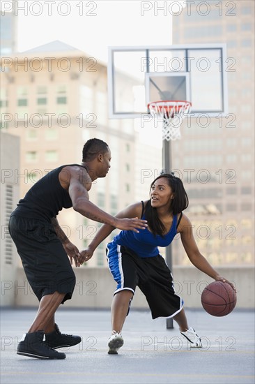 USA, Utah, Salt Lake City, young man and young woman playing basketball. Photo : Mike Kemp