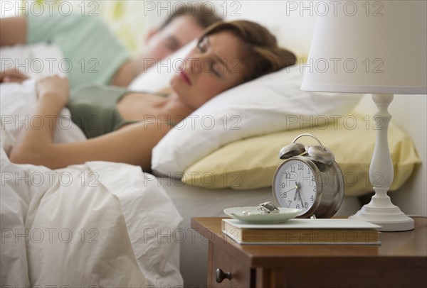 USA, New Jersey, Jersey City, Young couple sleeping in bed.