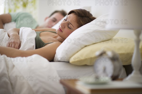 USA, New Jersey, Jersey City, Young couple sleeping in bed.