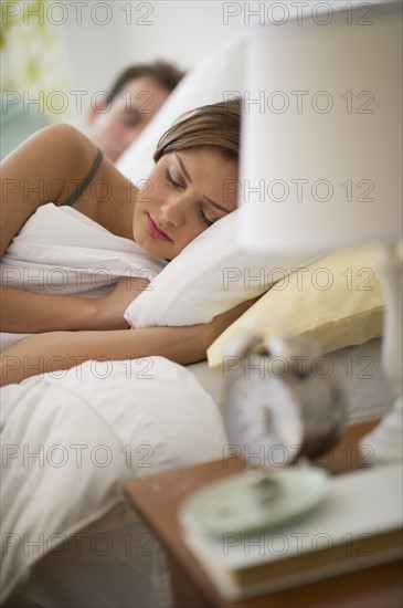 USA, New Jersey, Jersey City, Young couple sleeping in bed.