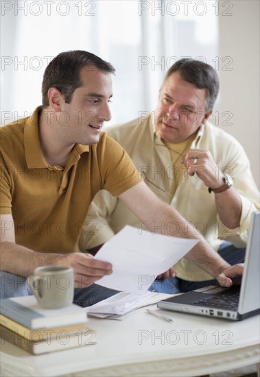 USA, New Jersey, Jersey City, Father and son using laptop in living room.