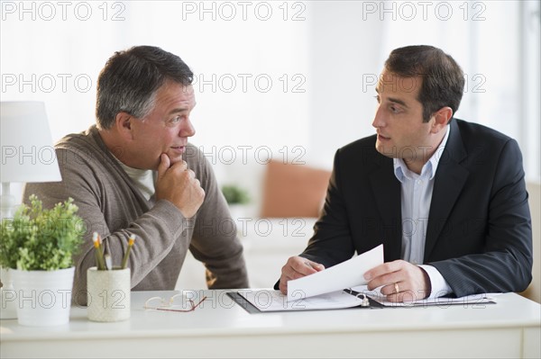 USA, New Jersey, Jersey City, Man talking with financial advisor in home.