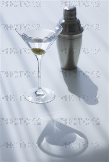 Cocktail shaker and cocktail in glass.