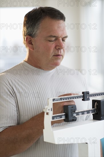 USA, New Jersey, Jersey City, Male patient on weighing scales in hospital.