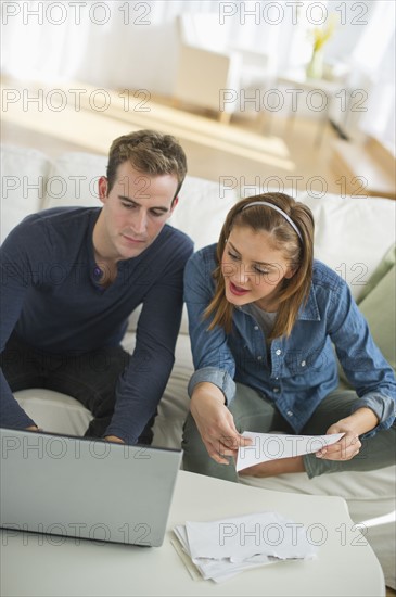 USA, New Jersey, Jersey City, Portrait of young couple doing paperwork at home.