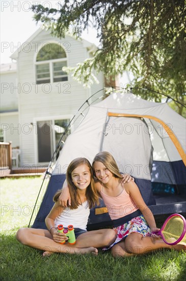 USA, New York, Two girls (10-11, 10-11) playing with tent in backyard. Photo : Jamie Grill Photography