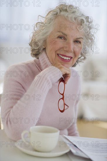 USA, New Jersey, Jersey City, Portrait of senior woman holding glasses.