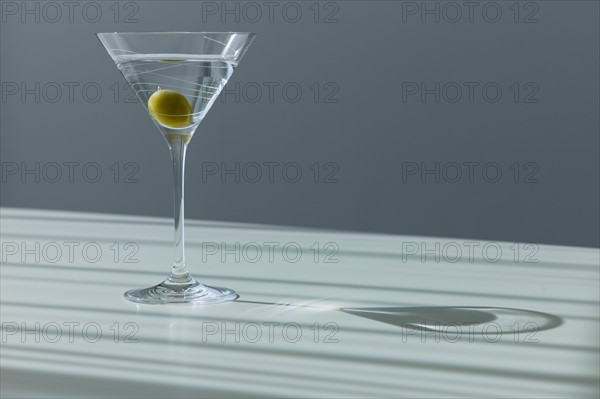 Cocktail with olive in glass.