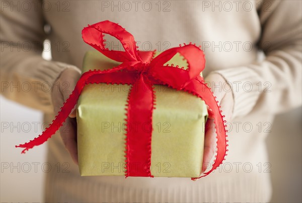 USA, New Jersey, Jersey City, Man holding gift box in front of him.