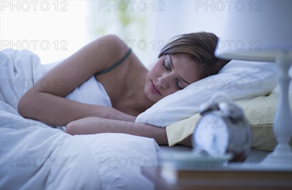 USA, New Jersey, Jersey City, Young woman sleeping in bed.