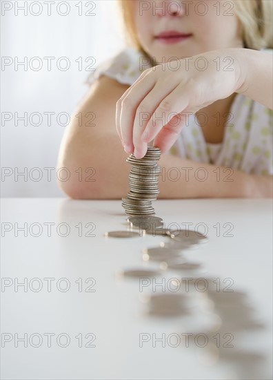 USA, New Jersey, Jersey City, Girl (8-9) playing with coins. Photo : Jamie Grill Photography