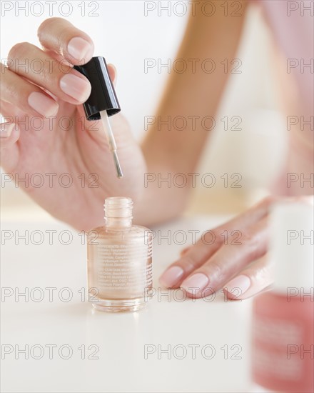 USA, New Jersey, Jersey City, Close-up view of woman painting fingernails. Photo : Jamie Grill Photography