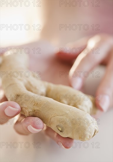 USA, New Jersey, Jersey City, Woman hand holding ginger root. Photo : Jamie Grill Photography