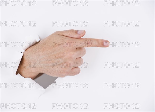 Hand on white background pointing. Photo : Daniel Grill