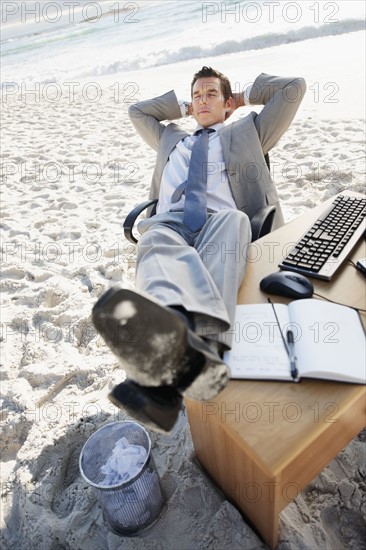 South Africa, Businessman relaxing on beach. Photo : momentimages
