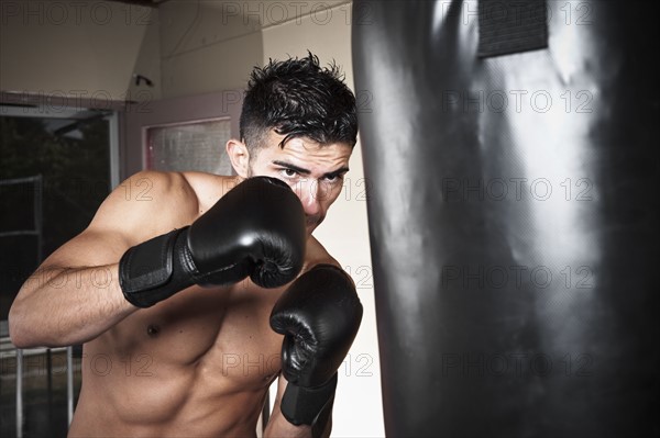 USA, Seattle, Portrait of young man boxing in gym. Photo : Take A Pix Media