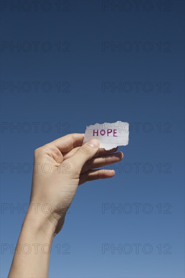 USA, Arizona, Winslow, Human hand holding paper with "hope" text on it. Photo : David Engelhardt