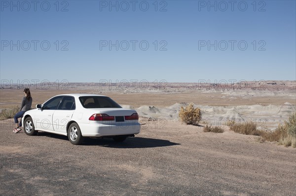 USA, Arizona, Painted Desert. Little Painted Desert, Woman leaning on car and looking at view. Photo : David Engelhardt