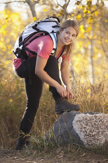USA, Utah, young woman, woman tying laces in forest. Photo : Mike Kemp