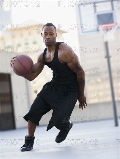 USA, Utah, Salt Lake City, young man playing basketball. Photo : Mike Kemp