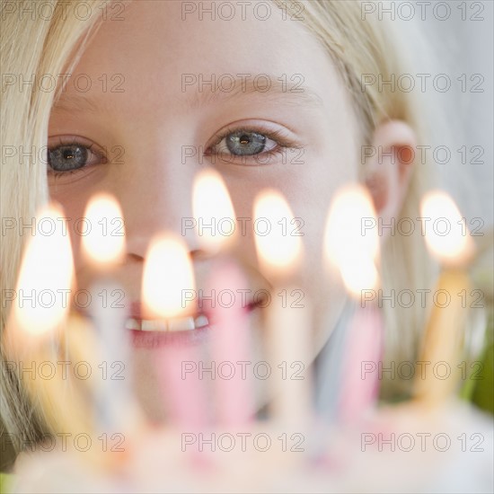 USA, New Jersey, Jersey City, Girl (8-9) in front of birthday cake. Photo : Jamie Grill Photography