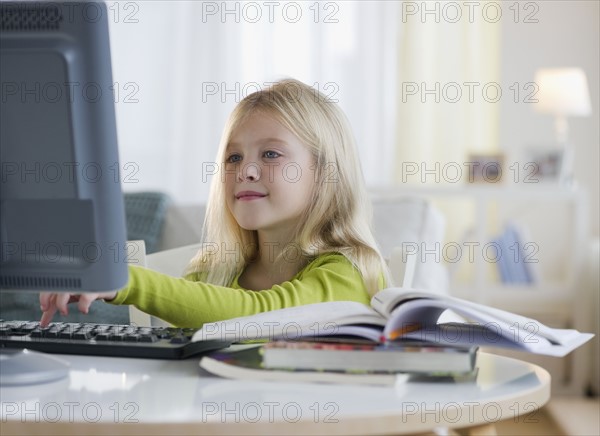 USA, New Jersey, Jersey City, Girl (8-9) sitting in front of computer. Photo : Jamie Grill Photography