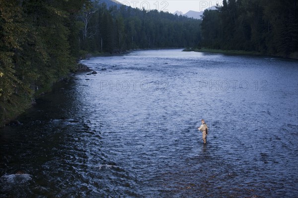 Canada, British Columbia, Fernie, Man fly fishing in river. Photo : Dan Bannister