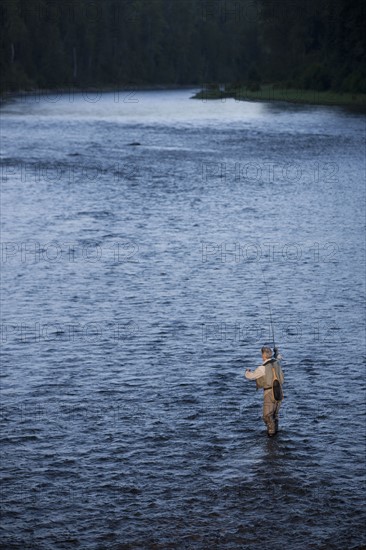 Canada, British Columbia, Fernie, Man fly fishing in river. Photo : Dan Bannister