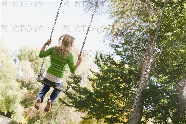 USA, Utah, girl (6-7) swinging on tree swing. Photo : Tim Pannell