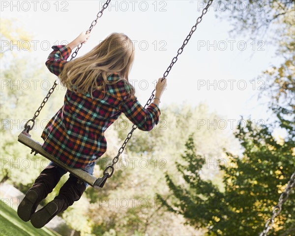 USA, Utah, girl (6-7) swinging on tree swing. Photo : Tim Pannell