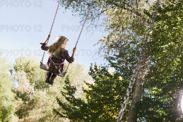 USA, Utah, girl (6-7) swinging on tree swing. Photo : Tim Pannell