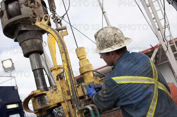 Oil worker drilling for oil on rig. Photo : Dan Bannister