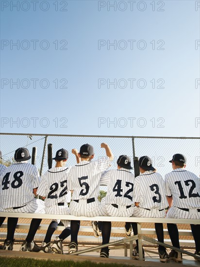 USA, California, Ladera Ranch, Boys (10-11) from little league sitting on bench, rear view.
