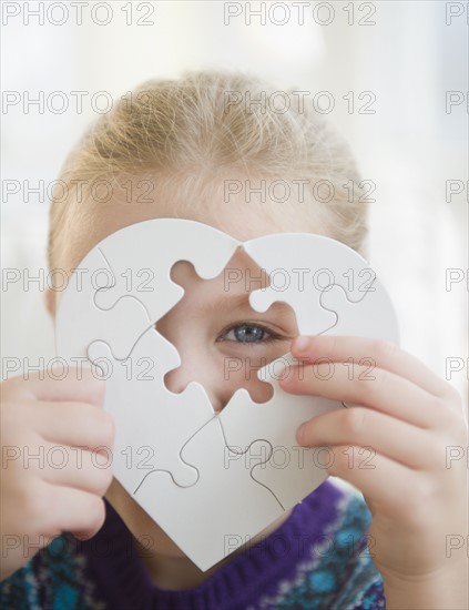 USA, New Jersey, Jersey City, Girl (8-9) holding puzzle heart. Photo : Jamie Grill Photography