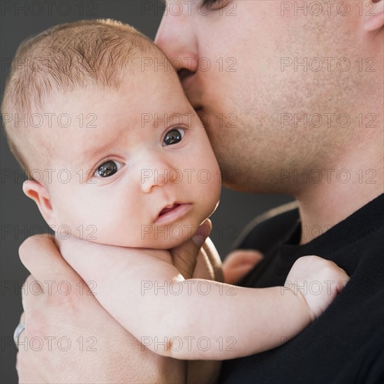USA, New Jersey, Jersey City, Father kissing baby daughter (2-5 months). Photo : Jamie Grill Photography