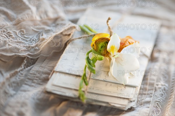 Flowers on pile of letters.