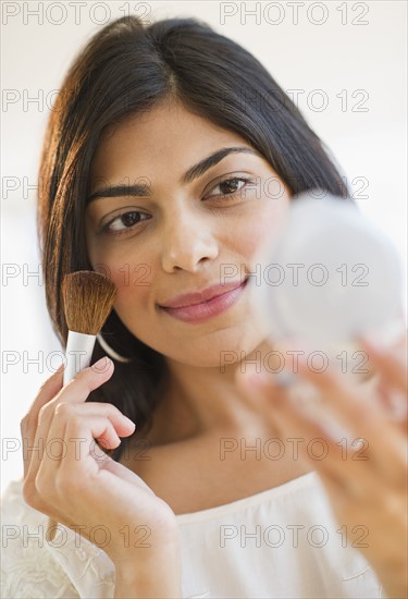 USA, New Jersey, Jersey City, Young attractive woman putting make-up on. Photo : Daniel Grill