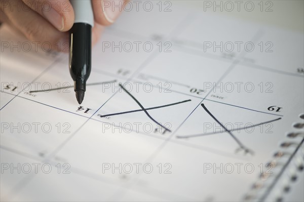 USA, New Jersey, Jersey City, Man writing on calendar.