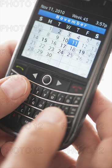 USA, New Jersey, Jersey City, Man holding mobile phone with calendar.