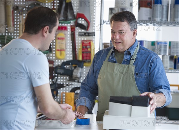 USA, New Jersey, Jersey City, Shop owner serving customer in hardware shop.