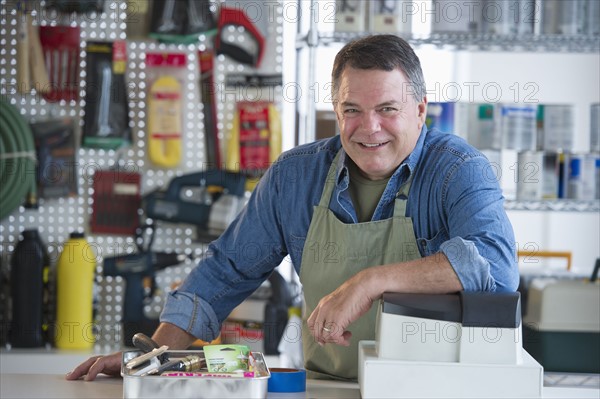 USA, New Jersey, Jersey City, Portrait of hardware shop owner at counter.