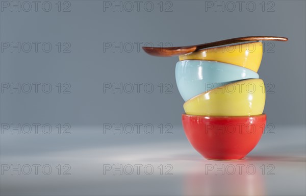 Colorful stacked bowls with spoon.