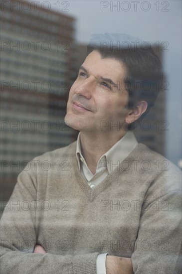 USA, New Jersey, Jersey City, Businessman looking through window.