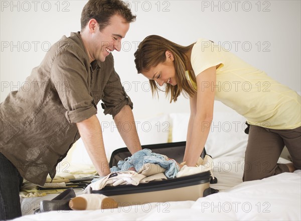 USA, New Jersey, Jersey City, Portrait of young couple packing clothes.