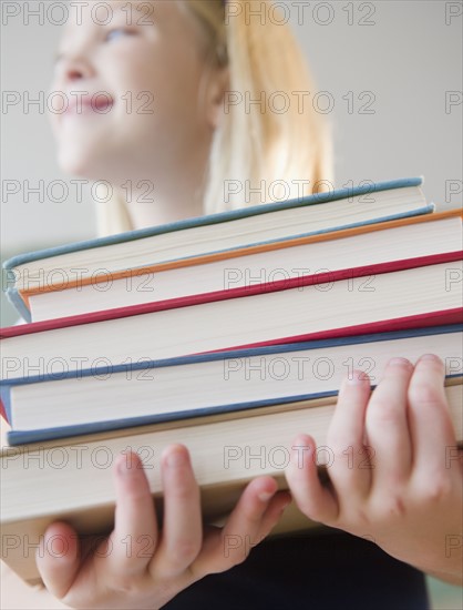 USA, New Jersey, Jersey City, Girl (8-9) carrying books. Photo : Jamie Grill Photography