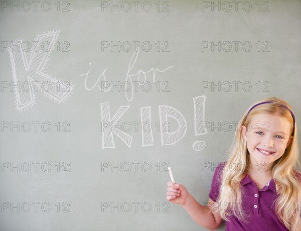 USA, New Jersey, Jersey City, Girl (8-9) writing on blackboard. Photo : Jamie Grill Photography