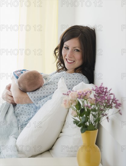 USA, New Jersey, Jersey City, Mother laying in bed with baby daughter (2-5 months). Photo : Jamie Grill Photography