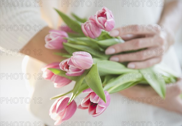 USA, New Jersey, Jersey City, Woman's hands holding bunch of pink tulips. Photo : Jamie Grill Photography