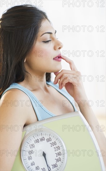 USA, New Jersey, Jersey City, Young attractive woman embracing scales. Photo : Daniel Grill