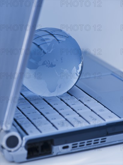 USA, New Jersey, Jersey City, Close-up view of blue laptop and globe. Photo : Daniel Grill